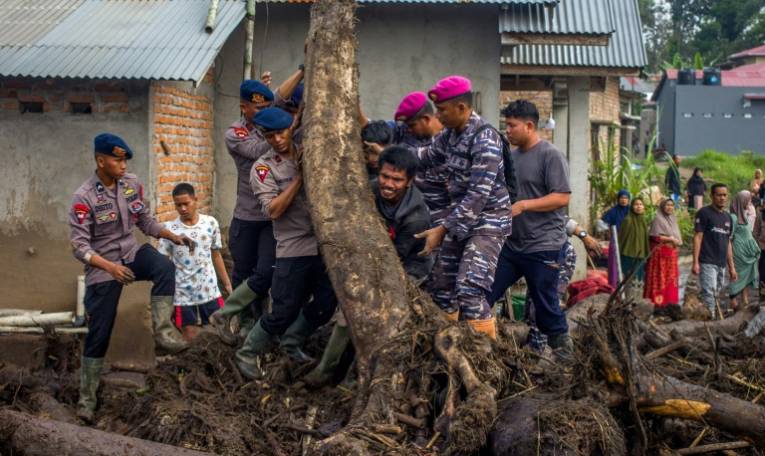 Des membres d'une équipe de secours et des habitants recherche des personnes disparues dans le village de Batu Taba, dans la province indonésienne d'Agam, dans l'ouest de l'île de Sumatra, le 14 mai 2024 ( AFP / REZAN SOLEH )