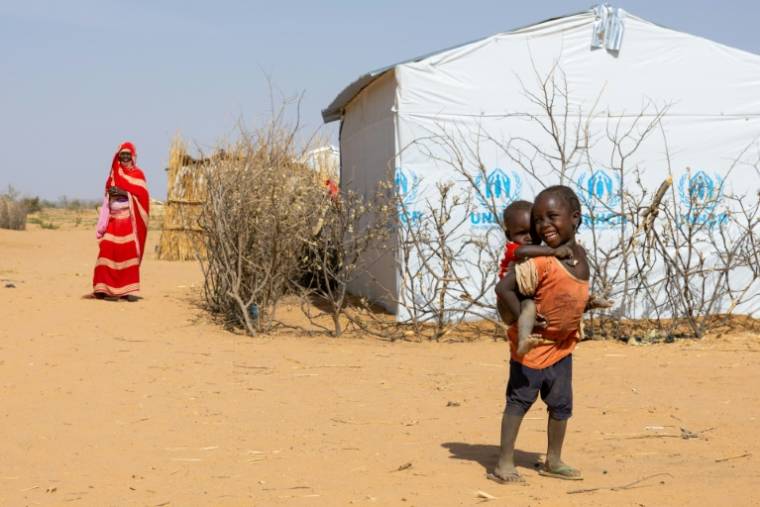 Deux jeunes réfugiés soudanais sont photographiés près d'un abri dans le camp de réfugiés de Farchana, le 7 avril 2024 ( AFP / Joris Bolomey )