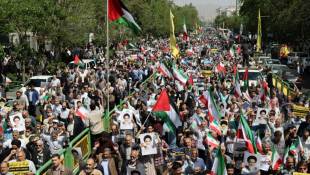 Des Iraniens défilent en brandissant des drapeaux palestiniens et de leur pays le 19 avril 2024 lors d'une manifestation anti-israélienne à Téhéran ( AFP / Atta KENARE )