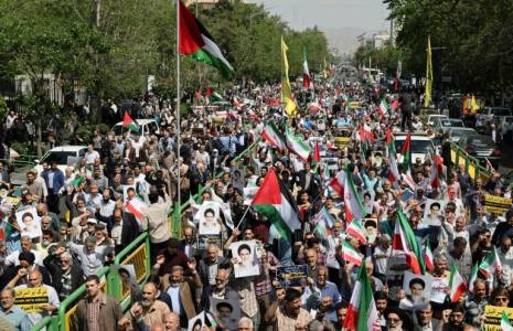 Des Iraniens défilent en brandissant des drapeaux palestiniens et de leur pays le 19 avril 2024 lors d'une manifestation anti-israélienne à Téhéran ( AFP / Atta KENARE )