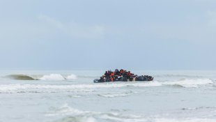 Des migrants se pressent sur le canot pneumatique d'un passeur pour tenter de traverser la Manche, après avoir quitté la plage de l'Ecault à Saint-Etienne-au-Mont, près de Neufchâtel-Hardelot, dans le Pas-de-Calais, le 30 octobre 2024 ( AFP / Sameer Al-DOUMY )