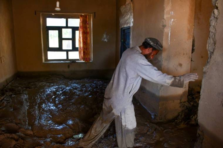Un homme Afghan marchant dans une maison détruite à cause des crues survenues dans le quartier de Burka dans la province de Baghlan, au nord du pays, le 12 mai 2024 ( AFP / Atif ARYAN )