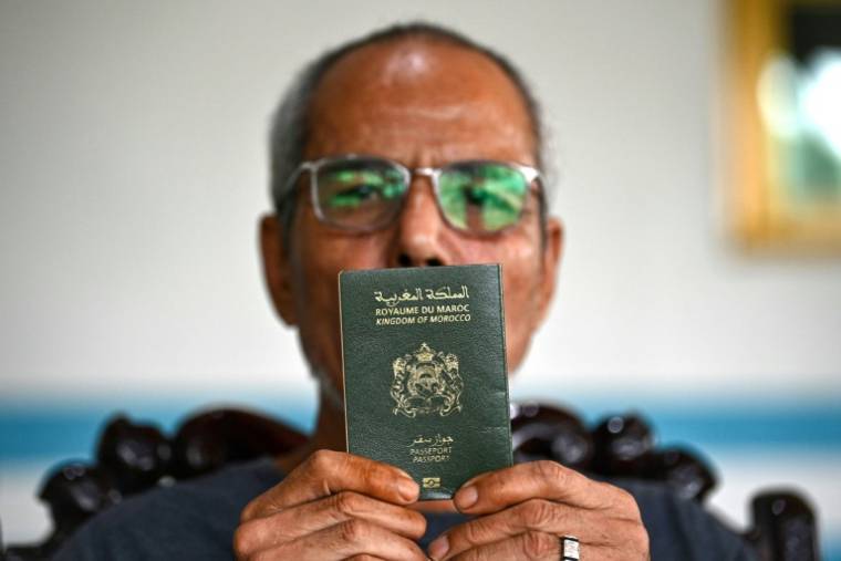 Le Tuan Binh (El Mekki Ali) montre son passeport marocain à son domicile, dans la province de Phu Tho, le 11 avril 2024 au Vietnam ( AFP / Nhac NGUYEN )