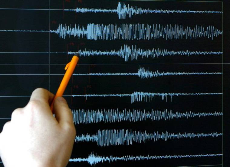 Un technicien pointe un graphique après un tremblement de terre