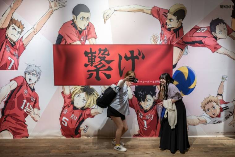 Des jeunes femmes font un selfie dans un magasin éphémère consacré au manga japonais de volley-ball "Haikyu !!", le 19 avril 2024 à Tokyo ( AFP / Yuichi YAMAZAKI )