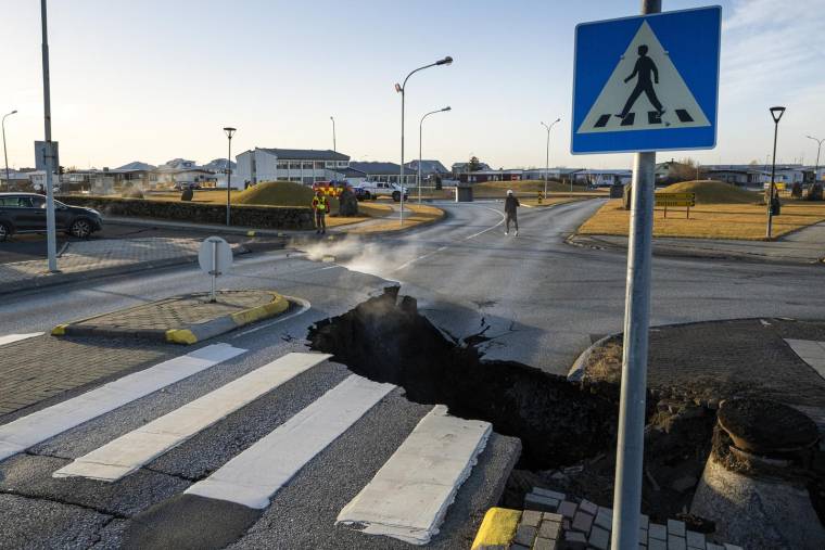 Photo prise le 13 novembre 2023 d'une une fissure traversant la route principale de Grindavik, dans le sud-ouest de l'Islande, à la suite de tremblements de terre provoqués par le déplacement du magma sous la croûte terrestre - signe précurseur d'une éruption volcanique. ( AFP / KJARTAN TORBJOERNSSON )