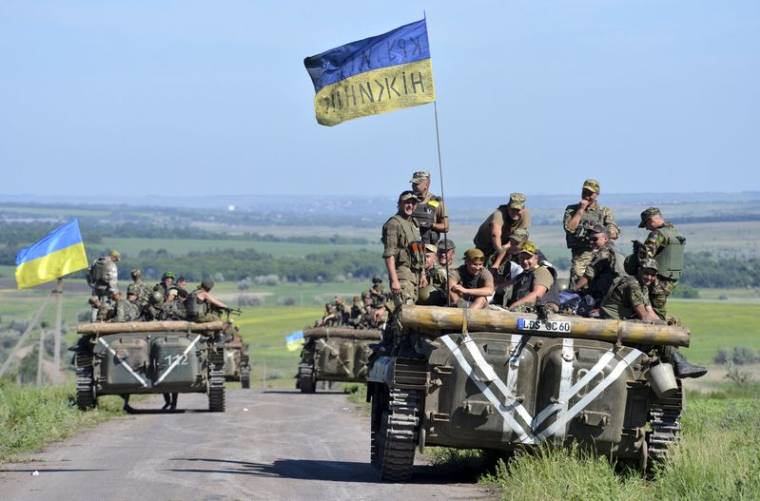 Members of Ukrainian armed forces gather on armoured vehicle on roadside near village of Vidrodzhennya