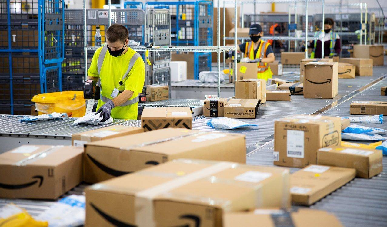 Deux employés d'Amazon en train de scanner des envois. (Crédit:  / Amazon)
