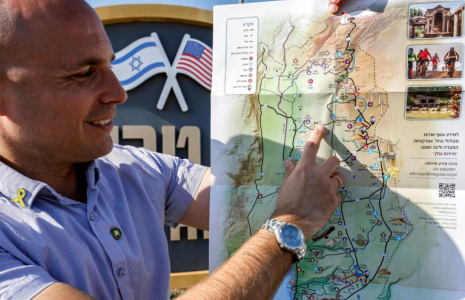 Yaakov Selavan, chef adjoint du conseil régional du plateau Golan, montre le point marquant "Trump Heights" lors d'une interview à l'entrée de la colonie dans le Golan annexé par Israël, le 17 décembre 2024 ( AFP / Jalaa MAREY )