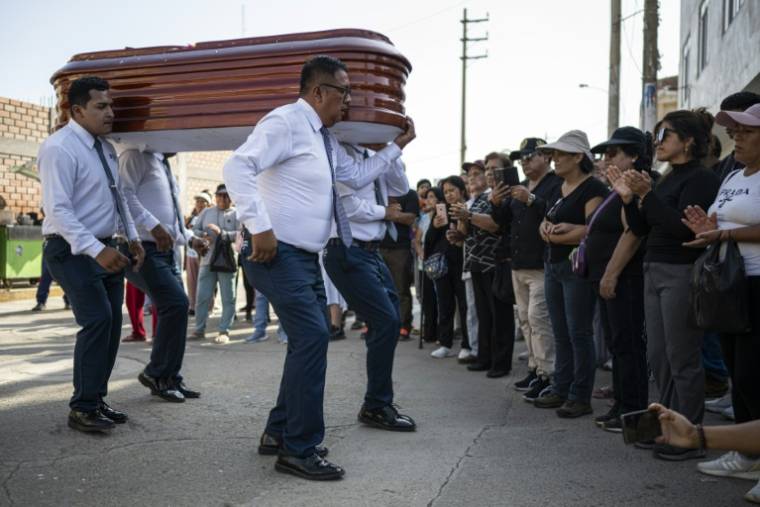 Des porteurs funéraires dansent en transportant le cercueil de Marcelino Jamanca lors de ses funérailles à Huacho, le 2 mai 2024 au Pérou ( AFP / Ernesto BENAVIDES )