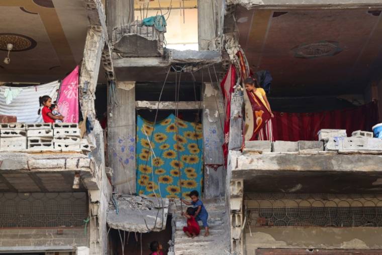 Des enfants palestiniens le 16 mai 2024 dans un bâtiment endommagé où ils ont trouvé refuge à Khan Younès, dans le sud de la bande de Gaza, où une guerre oppose Israël au mouvement islamiste palestinien Hamas ( AFP / - )
