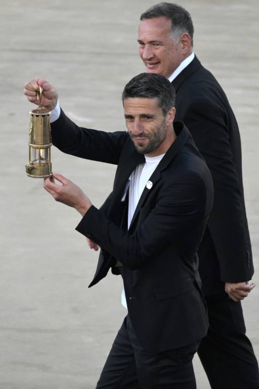 Tony Estanguet, président du comité d'organisation de Paris-2024, porte la lanterne contenant la flamme olympique, remise par la Grèce vendredi à l'occasion d'une cérémonie à Athènes   ( AFP / Angelos Tzortzinis )