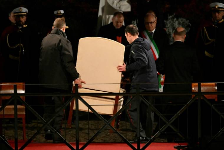 Le fauteuil du pape François est retiré après que le Vatican a annoncé que le pape ne participerait pas au Chemiin de croix au Colisée, lors des célébrations de la Semaine Sainte, le 29 mars 2024 à Rome ( AFP / Alberto PIZZOLI )