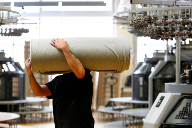 Un employé déplace des draperies dans la manufacture de l'entreprise textile "TRIGEMA" à Burladingen