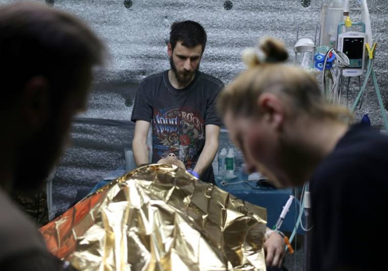 Des médecins militaires ukrainiens prodiguent les premiers soins à un soldat blessé, dans la région de Donetsk en Ukraine le 16 avril 2024 ( AFP / Anatolii STEPANOV )