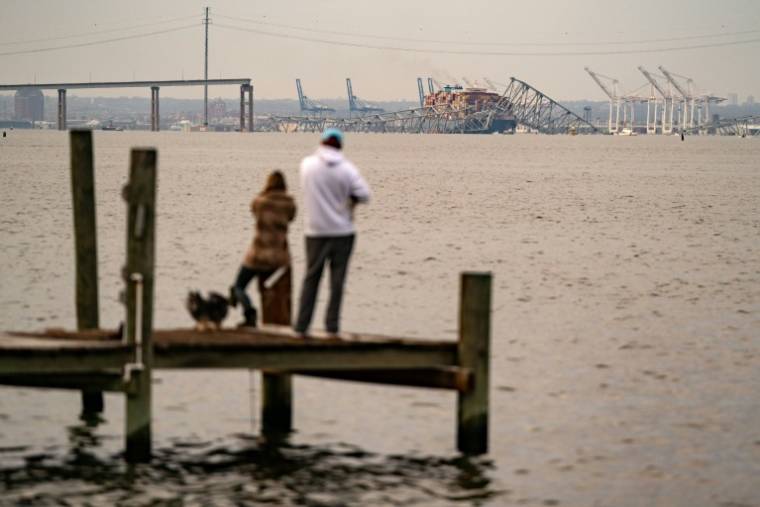 Devant les restes du pont Francis Scott Key après son effondrement, à Baltimore aux Etats-Unis le 26 mars 2024 ( AFP / Kent Nishimura )