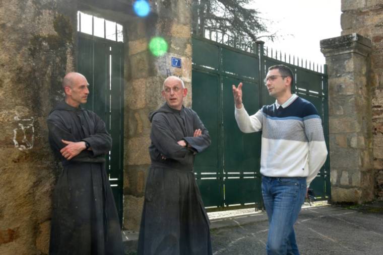 Le maire de Solignac, Alexandre Portheault (D), discute avec le père Benoît Joseph (C) et le père André à la porte de l'abbaye de Solignac, en Haute-Vienne, le 21 mars 2024  ( AFP / PASCAL LACHENAUD )