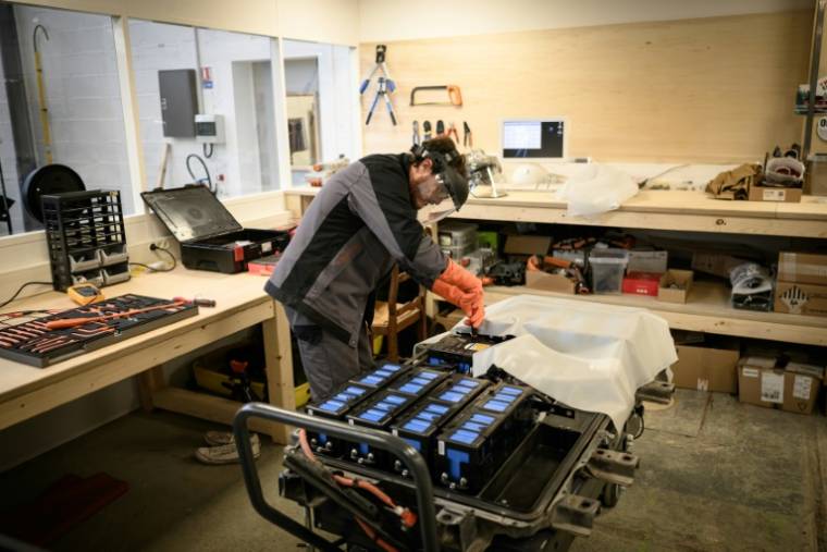 Un mécanicien travaille sur un module de batteries pour voiture électrique dans l'atelier de réparation spécialisé Revolte, à Carquefou (Loire-Atlantique), le 30 novembre 2022 ( AFP / LOIC VENANCE )