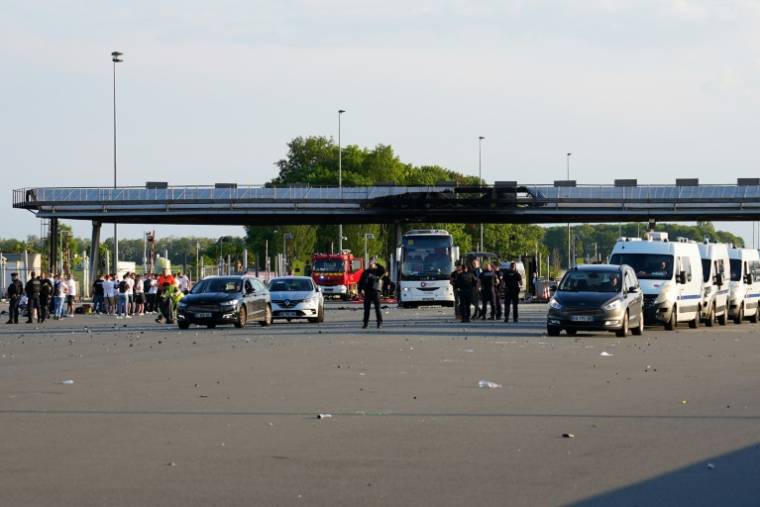 CRS near OL supporters near the Fresnes-lès-Montauban toll booth, in Pas-de-Calais, after clashes with PSG supporters just before the Coupe de France final in Lille, May 25 2024 (AFP / Pierre BEAUVILLAIN)
