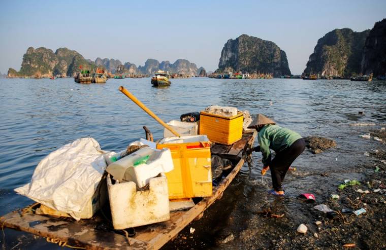 Un homme ramasse des déchets dans la baie d'Ha Long, au Vietnam, le 17 mai 2023 ( AFP / Nam NGUYEN )