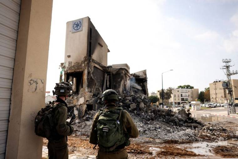 Les soldats israéliens regardent les restes d'un poste de police à Sderot, en Israël