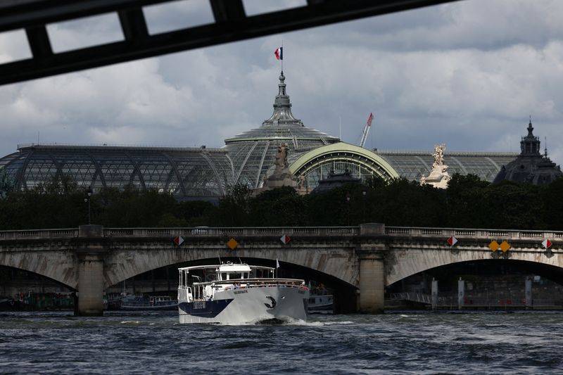Des touristes voyagent sur un bateau d'excursion le long de la Seine, près du Grand Palais à Paris