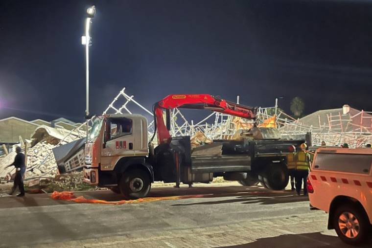 Un camion-pelleteuse sur le site de l'effondrement d'un immeuble en construction à George, le 6 mai 2024 en Afrique du Sud ( AFP / Willie van Tonder )