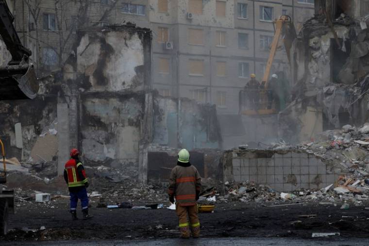 Les services de secours travaillent sur le site où un immeuble d'habitation a été endommagé par un tir de missile russe, à Dnipro