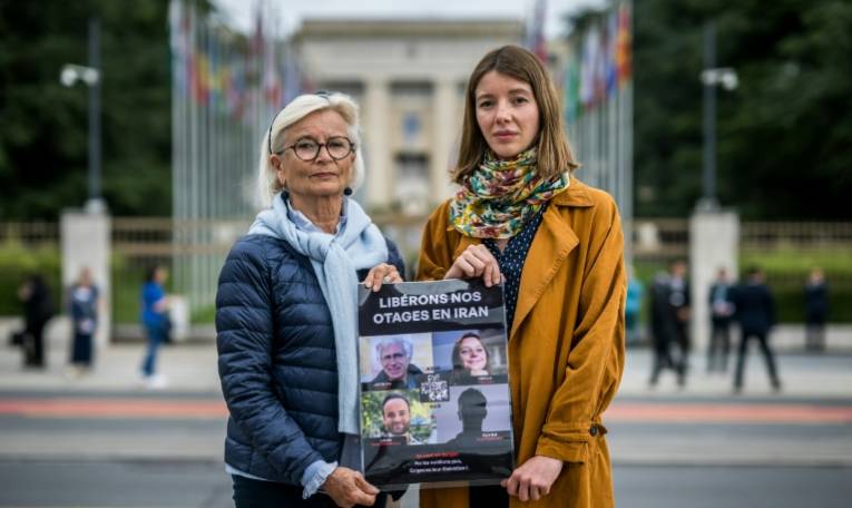 Sylvie Arnaud, mère de Louis Arnaud (g) et Noemie Kohler, sœur de Cécile Kohler (d), deux parents de Français détenus en Iran, posent devant les bureaux des Nations Unies à Genève, le 27 mai 2024 ( AFP / Fabrice COFFRINI )