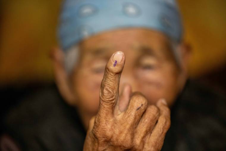 Une femme âgée montre la marque sur son doigt après avoir voté depuis son domicile avec une urne portable, le 27 juin 2024, un jour avant les élections législatives mongoles à Oulan-Bator, la capitale de la Mongolie. ( AFP / Byambasuren BYAMBA-OCHIR )