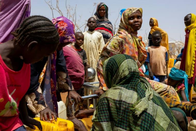 Des réfugiés soudanais se rassemblent pour remplir des bidons d'eau dans le camp de réfugiés de Farchana, le 8 avril 2024 ( AFP / Joris Bolomey )