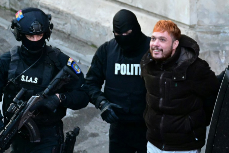 Le trafiquant de drogue français Mohamed Amra (c) escorté par des policiers hors de la Cour d'appel de Bucarest, le 23 février 2025, au lendemain de son arrestation en Roumanie ( AFP / Daniel MIHAILESCU )