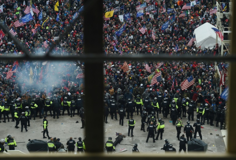 Des policiers tentent de repousser des partisans de Donald Trump devant le Capitole de Washington, le 6 janvier 2021 ( AFP / Olivier DOULIERY )