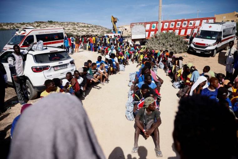 Des personnes migrantes attendent d'être transférées sur le continent, depuis Lampedusa en Italie