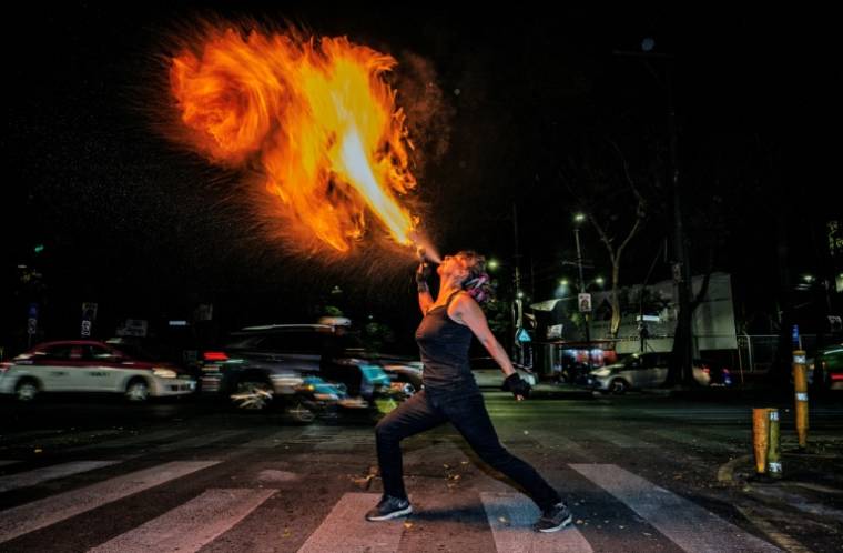 L'activiste féministe et artiste de rue Flor de Fuego crache du feu à un carrefour de Mexico le 15 mai 2024 ( AFP / CARL DE SOUZA )