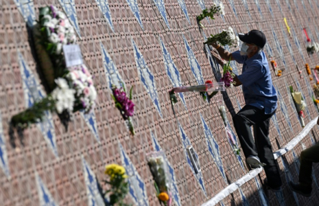 Un homme dépose des fleurs devant le Mur-mémorial du tsunami à Ban Nam Khem, en Thaïlande, le 26 décembre 2024 ( AFP / Lillian SUWANRUMPHA )