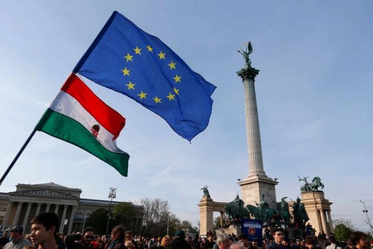 People wave Hungarian and European Union flags as they protest in Heroes’ square against a new law that would undermine Central European University in Budapest