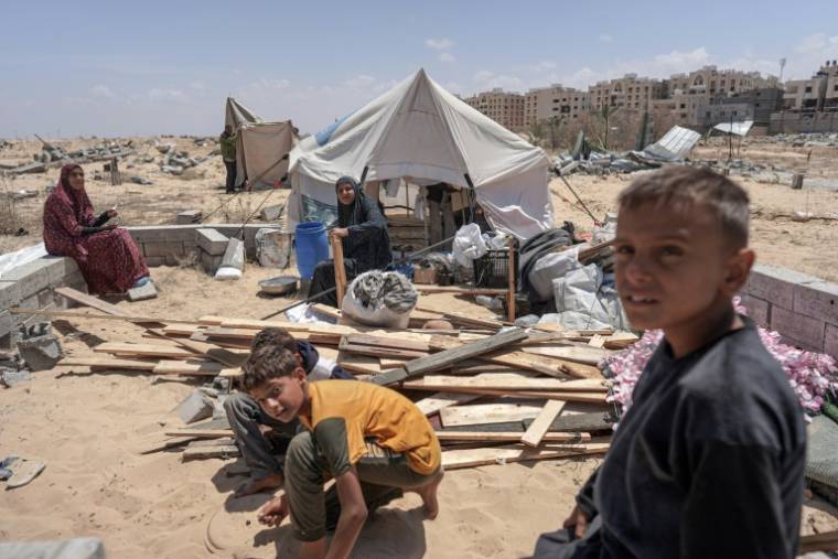 Des Palestiniens qui ont fui Rafah, dans le sud de la bande de Gaza, devant leur tente de fortune à Khan Younès, un peu plus au nord, le 12 mai 2024 ( AFP / - )