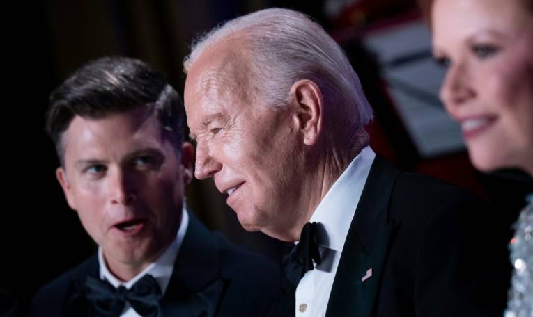 Le président américain Joe Biden (centre) assiste au dîner annuel des correspondants de la Maison Blanche au côté du comédien Colin Jost (gauche), le 27 avril 2024 à Washington ( AFP / Brendan Smialowski )