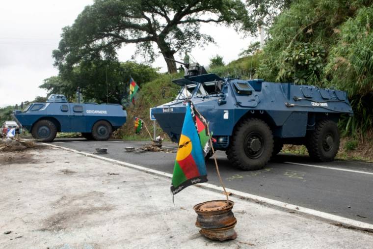 Des véhicules blindés de la gendarmerie dégageant la chaussée au col de La Pirogue, dans la commune de Paita, en Nouvelle-Calédonie, le 19 mai 2024 ( AFP / Delphine Mayeur )