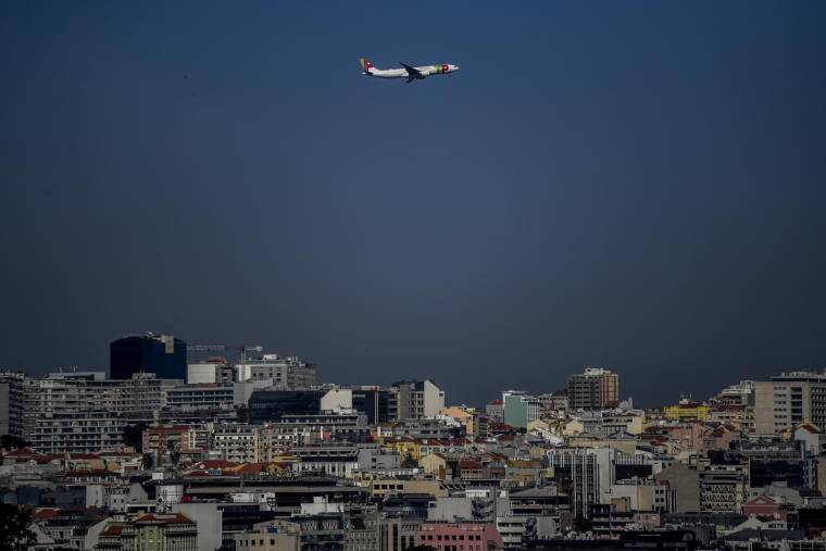 Un avion de la compagnie aérienne TAP survole Lisbonne, au Portugal, le 5 avril 2021. ( AFP / PATRICIA DE MELO MOREIRA )