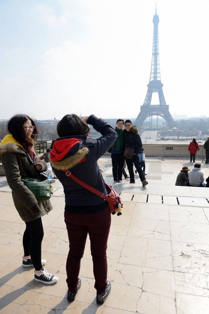 Des touristes chinois prennent des photos devant la tour Eiffel, le 27 mars 2013 à Paris. ( AFP / ERIC FEFERBERG )