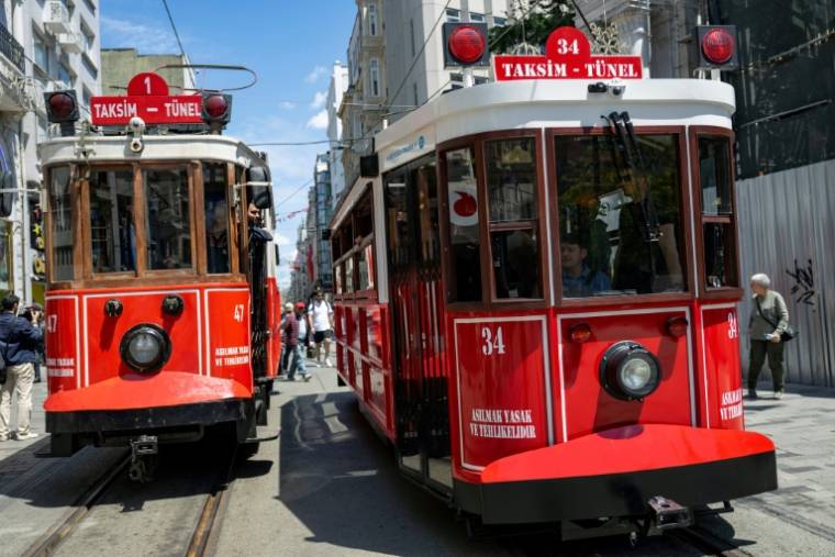 L'emblématique tramway rouge et blanc d'Istanbul, en version classique à gauche, en version moderne, avec batteries électriques à droite, en Turquie le 15 mai 2024 ( AFP / Yasin AKGUL )