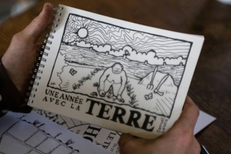 Samuel Lewis montre une de ses oeuvres, un livre qu'il a lui même confectionné, le 2 avril 2024 à Duault, dans les Côtes-d'Armor ( AFP / Fred TANNEAU )