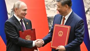 Le président russe Vladimir Poutine et le président chinois Xi Jinping échangent des documents à Pékin le 16 mai 2024. Photographie distribuée par l'agence d'État russe Spoutnik ( POOL / Sergei BOBYLYOV )
