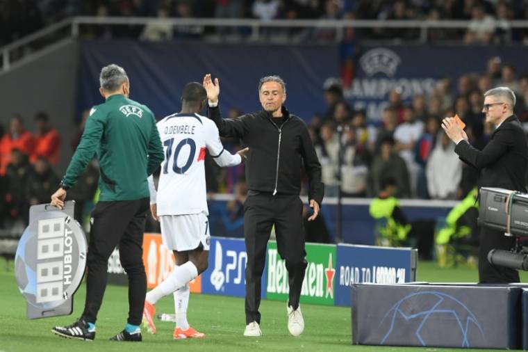 Luis Enrique félicite Ousmane Dembélé lors de sa sortie à la 88e minute du quart de finale retour de la Ligue des champions le 16 avril 2024 Barcelone. "C'est l'une des meilleures recrues de la saison et un joueur vital pour nous", dit de son attaquant l'entraîneur espagnol du PSG ( AFP / Josep LAGO )
