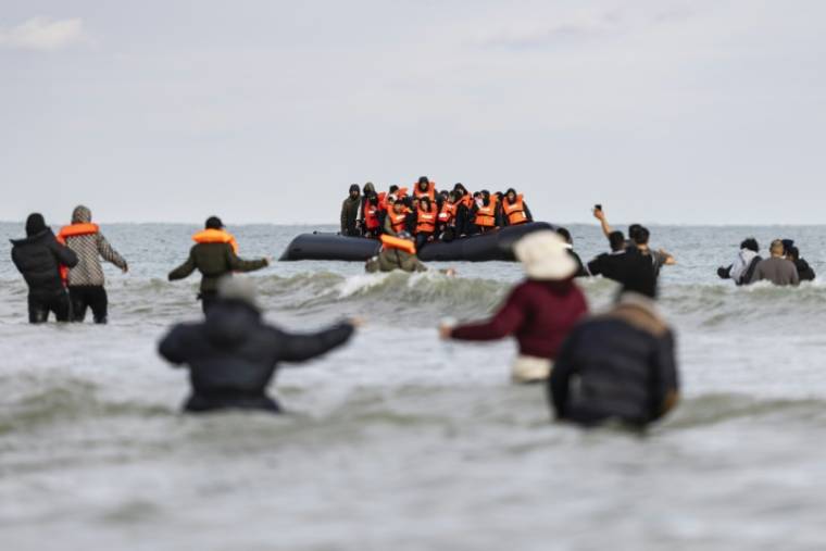 Des migrants tentent de rejoindre le bateau d'un passeur pour  traverser la Manche, sur la plage de Gravelines, près de Dunkerque, dans le nord de la France, le 26 avril 2024 ( AFP / Sameer Al-DOUMY )