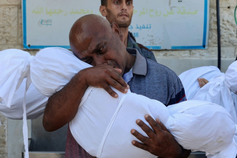 Un homme pleure au-dessus du corps enveloppé d'un enfant tué lors d'une frappe à Deir el-Balah, dans le centre de la bande de Gaza, le 10 août 2024 ( AFP / Eyad BABA )