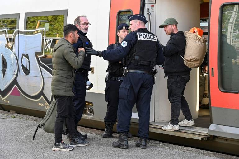 La police empêche les migrants de monter à bord d'un train à la gare des Fontinettes, à Calais, le 29 avril 2024 ( AFP / Bernard BARRON )