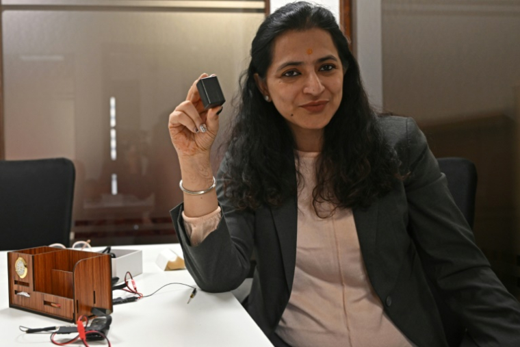 Akriti Khatri, fondatrice de Venus Detective Agency, montre un traceur GPS et un mouchard audio lors d'une interview avec à New Delhi le 7 décembre 2024 ( AFP / Arun SANKAR )